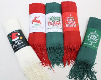 May include: Four different Christmas themed scarves with festive designs and text. The scarves are red, green, white, and green. The text on the scarves reads "Merry Christmas" and "We wish you a merry Christmas".