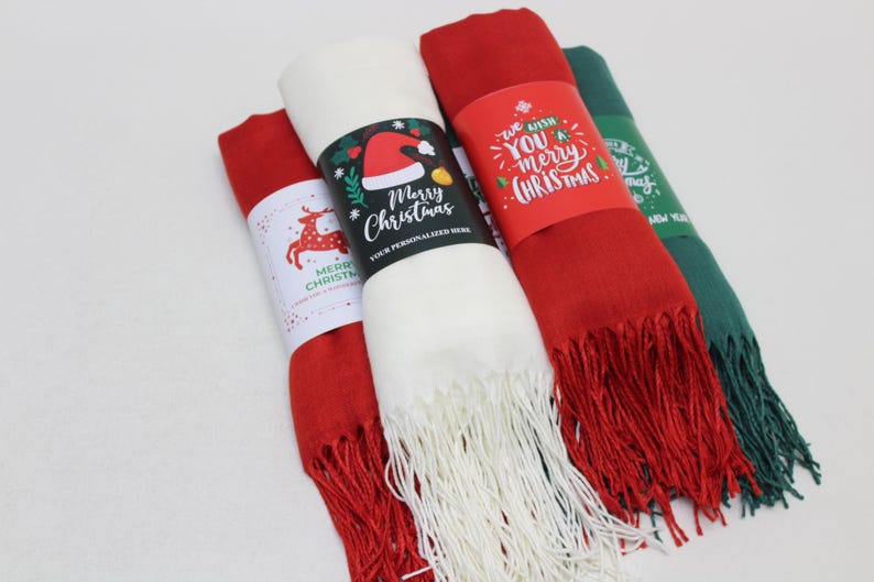 Pode incluir: Tr&ecirc;s cachec&oacute;is com tema natalino com etiquetas festivas. Os cachec&oacute;is s&atilde;o vermelhos, brancos e verdes. As etiquetas t&ecirc;m diferentes sauda&ccedil;&otilde;es de Natal, incluindo "We wish you a merry Christmas" e "Merry Christmas".
