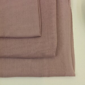May include: Three pieces of soft, dusty rose colored fabric stacked on top of each other.