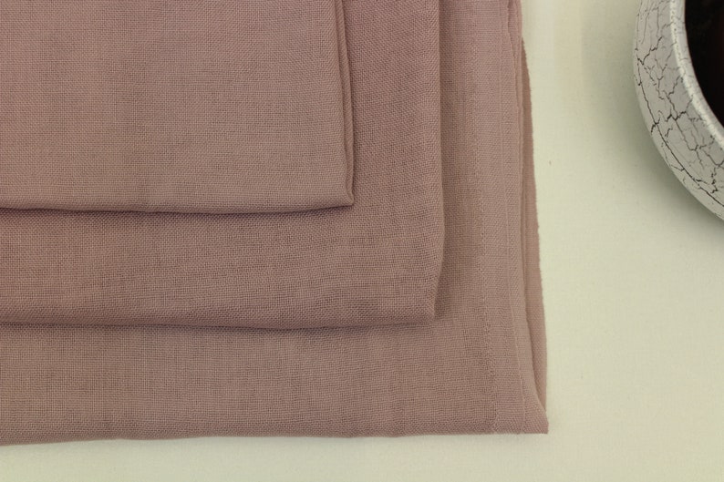 May include: Three pieces of soft, dusty rose colored fabric stacked on top of each other.