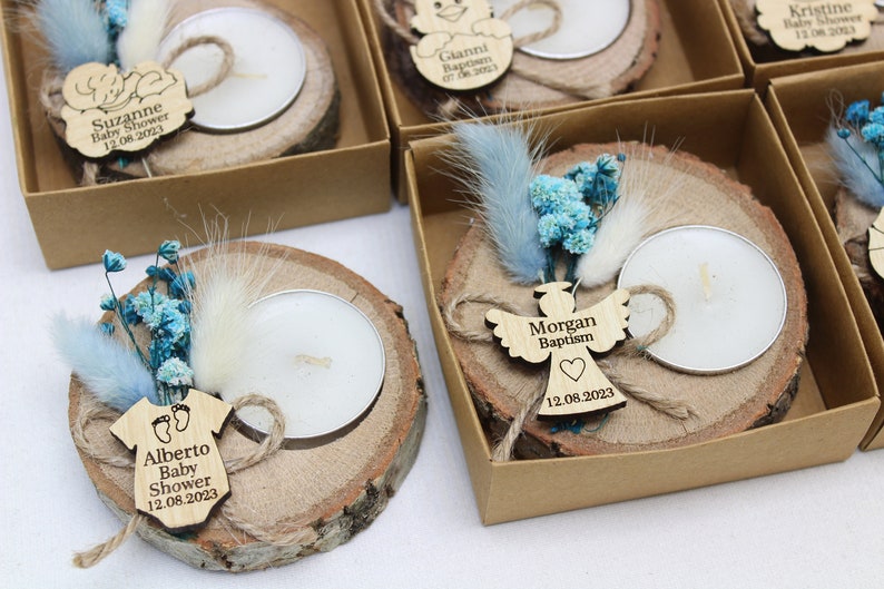 Op de afbeelding: Een set kleine houten kaarshouders met een theelichtje, gedroogde bloemen en een gepersonaliseerd houten label. De labels bevatten namen en gebeurtenissen zoals "Baby Shower" en "Doop".