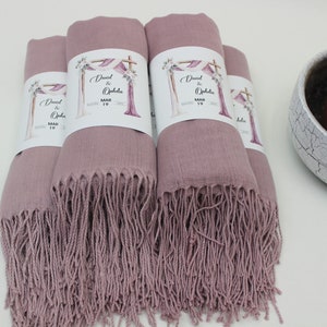 May include: Four dusty rose pashmina shawls with white labels that say "David & Ophelia" and "May 19".
