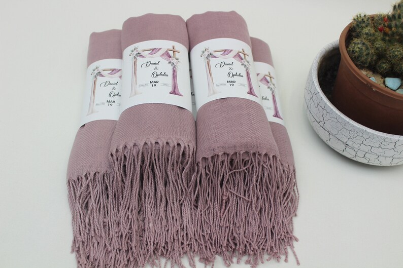 May include: Four dusty rose pashmina shawls with white labels that say "David & Ophelia" and "May 19".