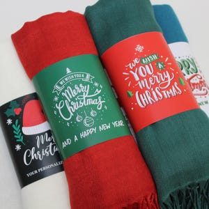 Pode incluir: Quatro cachec&oacute;is de cores diferentes com etiquetas de presente com tema natalino. As etiquetas t&ecirc;m letras verdes e brancas com as palavras "We wish you a Merry Christmas and a Happy New Year".