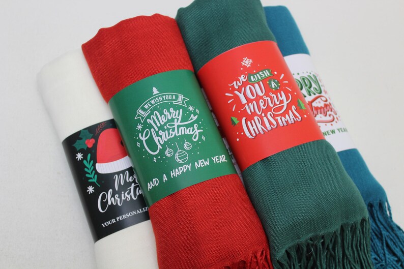 Pode incluir: Quatro cachec&oacute;is de cores diferentes com etiquetas de presente com tema natalino. As etiquetas t&ecirc;m letras verdes e brancas com as palavras "We wish you a Merry Christmas and a Happy New Year".