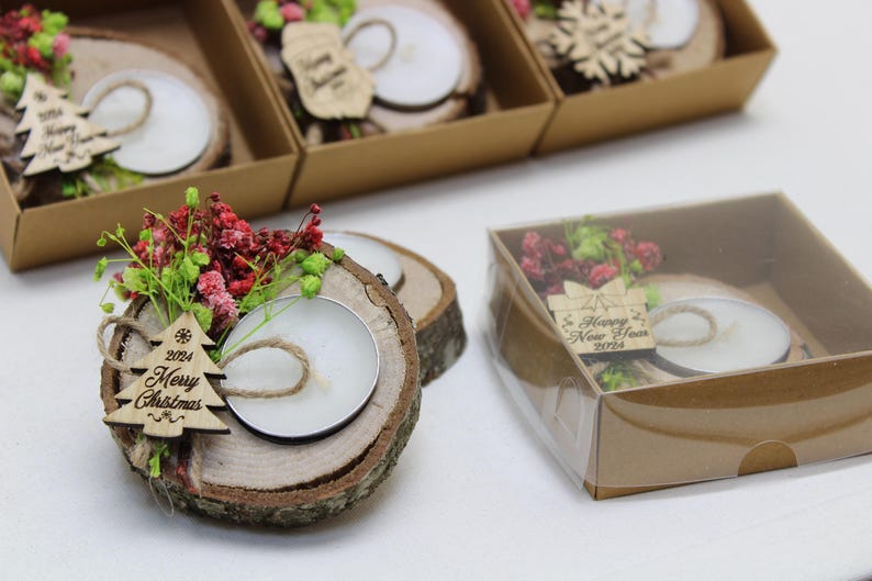 May include: A set of small wooden candle holders with a clear glass votive candle, decorated with dried flowers and a wooden ornament that says "2024 Merry Christmas".