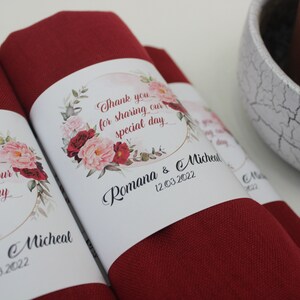 May include: Red fabric wrapped around a white card with a floral design and the text "Thank you for sharing our special day Romana & Micheal 12.03.2022".