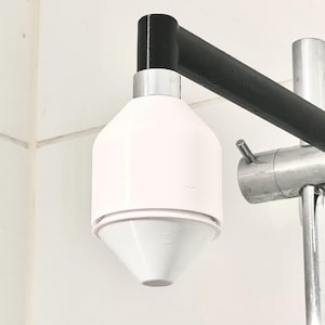 May include: A white shower head with a black and silver arm. The shower head has a round, cone-shaped design.