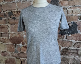 May include: A grey short-sleeved t-shirt on a mannequin.