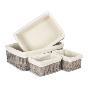 May include: Set of four grey wicker storage baskets with white fabric liners. The baskets are nested inside each other, with the largest basket at the bottom and the smallest basket at the top.