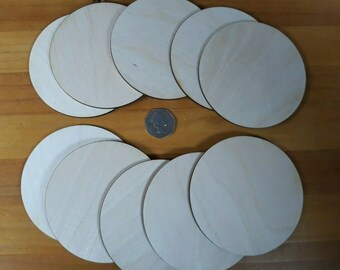 May include: A set of 12 unfinished wooden circles, perfect for crafting projects. The circles are arranged in two rows, with a coin in the center for size reference.