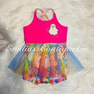 May include: A pink and rainbow-colored girls' dress with a ghost design. The dress has a pink tank top with a sparkly ghost applique and a rainbow tulle skirt with white polka dots.