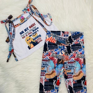 May include: A white tank top with a red, white, and blue graphic print that says "Oh My God! You look like the 4th of July. Makes me want a hotdog real bad."  The tank top is paired with red, white, and blue patterned leggings.