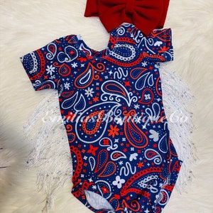 May include: A blue and red paisley print baby onesie with short sleeves. A red bow headband is included.