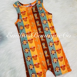 May include: A sleeveless, orange, brown, and blue striped romper with a pattern of smiling faces, cacti, and cowboy boots.