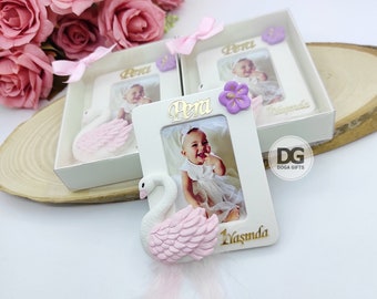 May include: White picture frame with a pink swan figurine, a purple flower, and the name "Pera" in gold lettering. The frame has a photo of a baby girl and the text "1 Yasinda".