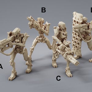 May include: Four beige plastic miniature robots with different weapons and poses. The robots are standing on a grey surface.