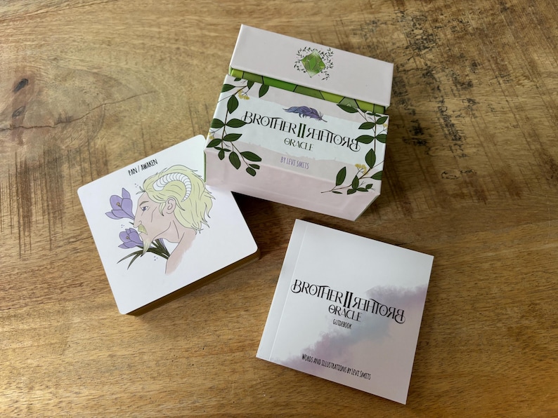 May include: A Brother II Brother Oracle deck with a guidebook. The box is pink with green floral designs and the text "Brother II Brother Oracle" and "By Love Saints". The guidebook is white with the text "Brother II Brother Oracle Guidebook" and "Words and Illustrations by Love Saints".