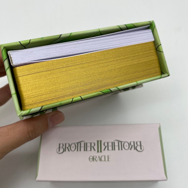May include: A green and gold box with a deck of cards inside. The box has a green and white pattern and the text "Brother II Brother Oracle" on the front.