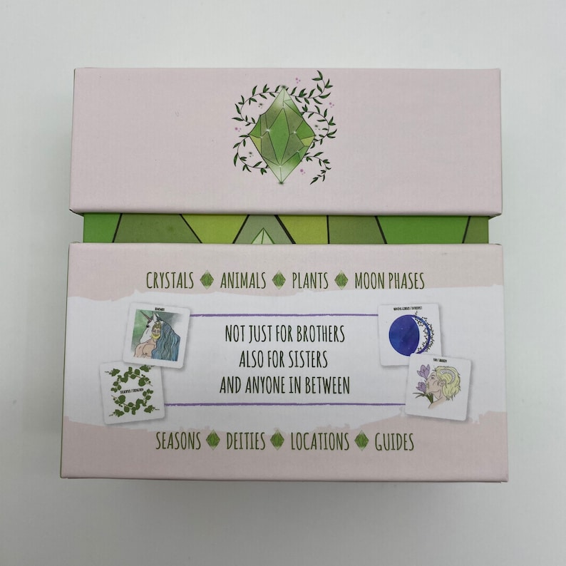 May include: A pink box with a green crystal design on the top and a green and white geometric pattern on the bottom. The box contains cards with illustrations of crystals, animals, plants, moon phases, seasons, deities, locations, and guides. The text on the box reads "Not just for brothers also for sisters and anyone in between."