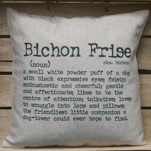 May include: A white linen cushion with black text that reads "Bichon Frise (noun) aka. bichon a small white powder puff of a dog with black expressive eyes; feisty; enthusiastic and cheerful; gentle and affectionate; likes to be the centre of attention; talkative; loves to snuggle into laps and pillows; the friendliest little companion a dog-lover could ever hope to find."