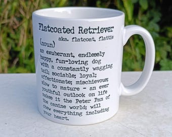 May include: White ceramic mug with a black and white graphic design. The mug features a definition of a Flatcoated Retriever, describing the dog as "an exuberant, endlessly happy, fun-loving dog".