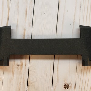 May include: Black plastic case with a textured surface. The case is designed to hold a handheld gaming device.