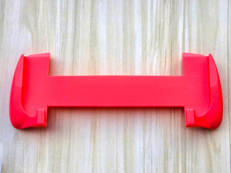 Puede incluir: Una funda de silicona rosa brillante para un dispositivo de juego port&aacute;til. La funda tiene dos piezas separadas que se unen para proteger el dispositivo.