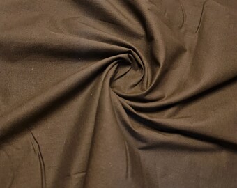 May include: A close-up of a brown fabric with a smooth texture. The fabric is folded and draped, creating soft folds and curves.