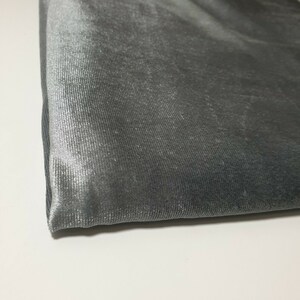 May include: Close-up of a piece of gray fabric with a subtle sheen. The fabric has a textured, ribbed surface.