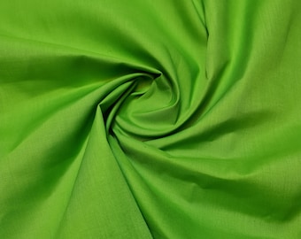 May include: A close-up of a bright green fabric with a smooth texture. The fabric is folded and draped, creating a soft, flowing look.