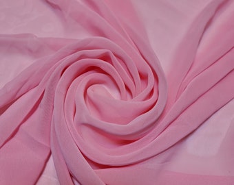 Könnte beinhalten: Ein weicher, rosa Chiffonstoff, der in einem wirbelnden Muster drapiert ist. Der Stoff ist durchscheinend und zart, mit einem subtilen Glanz.
