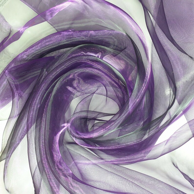 May include: Purple sheer fabric with a shimmery finish, draped and folded to create a swirling pattern.