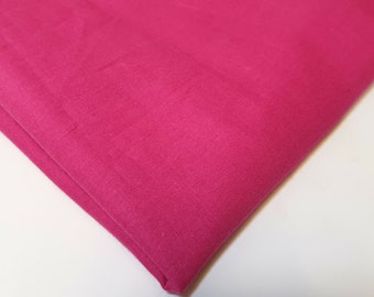 Peut inclure: Un morceau de tissu rose vif uni plié en deux. Le tissu a une texture lisse et uniforme.