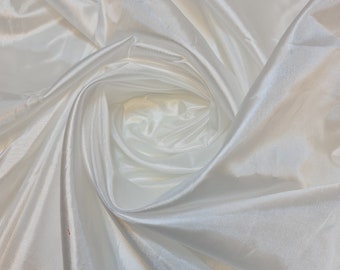 May include: White satin fabric with a smooth, silky texture. The fabric is draped and folded, creating a soft, flowing look.