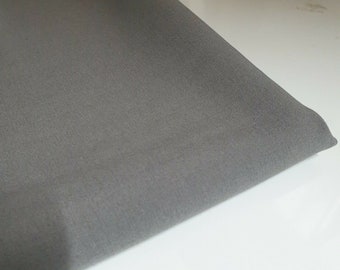 May include: A close-up of a piece of gray fabric. The fabric has a smooth, even texture.