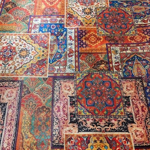 Könnte beinhalten: Ein Textilstoff mit einem Patchwork-Design aus verschiedenen rechteckigen und quadratischen Abschnitten. Jeder Abschnitt zeigt komplexe, farbenfrohe Muster, darunter florale Motive, geometrische Formen und Paisley-Designs in Rot-, Blau-, Gold- und Weißtönen.
