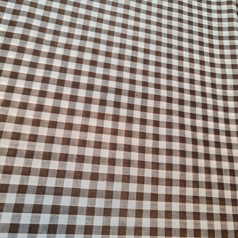 May include: Brown and white checkered fabric with a subtle diagonal pattern.