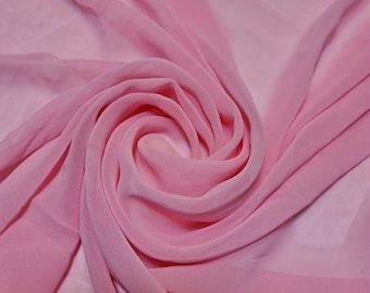 Könnte beinhalten: Ein weicher, rosa Chiffonstoff mit einer zarten, fließenden Textur. Der Stoff ist drapiert und gefaltet und erzeugt ein Wirbelmuster.