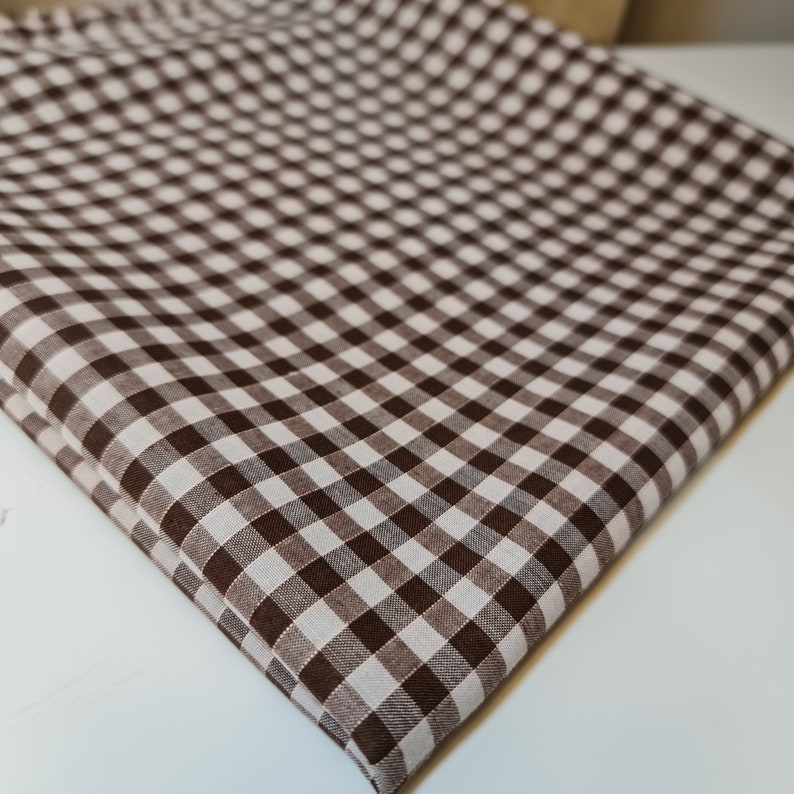 May include: Brown and white gingham fabric with a checkered pattern.