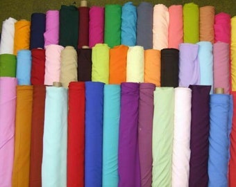 May include: A collection of fabric rolls in various colors, including red, blue, green, orange, yellow, purple, pink, brown, and white. The fabric rolls are arranged in a row, with the ends of the rolls facing the viewer.