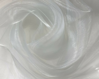 May include: White sheer fabric with a slight shimmer. The fabric is draped and folded, showing its texture and transparency.