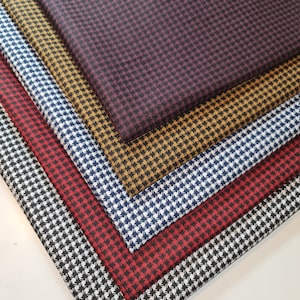 May include: Five different fabric swatches with a houndstooth pattern. The swatches are in black and white, red and white, navy and white, mustard yellow and black, and burgundy and black.