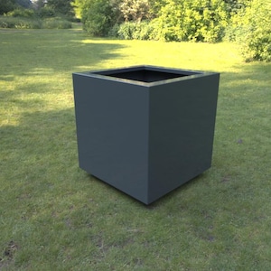 May include: A dark grey, cube-shaped planter box on a grassy lawn. The modern, geometric design has a square opening at the top and is suitable for outdoor use. The planter's dimensions are approximately 61 cm wide, 61 cm deep, and 61 cm high.