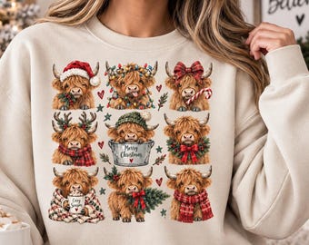 Puede incluir: Una sudadera beige de cuello redondo con una cuadrícula de nueve ilustraciones de vacas Highland decoradas para Navidad. Las vacas llevan gorros de Papá Noel, bufandas y lazos, o están rodeadas de luces, vegetación y un cubo.