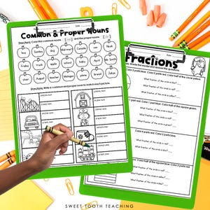 May include: A printable worksheet for teaching common and proper nouns. The worksheet features a colorful design with pictures of a roller coaster, a house, a car, a boot, and a ship. The worksheet also includes a section for fractions with a circle divided into sections and questions about the fractions of the circle.
