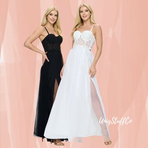 May include: Two women wearing long, flowing dresses with lace bodices and sheer skirts. The dress on the left is black and the dress on the right is white. Both dresses have a high slit in the front.