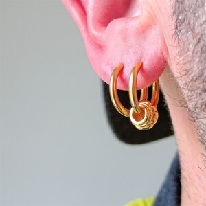 Gold steel hoop earring with gold charm - sun reflection