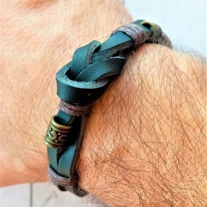 Braunes geflochtenes Lederarmband mit alten goldenen Stahlanhängern und Verschluss.