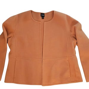 May include: A long-sleeved, open-front, peach-colored jacket with a collar.